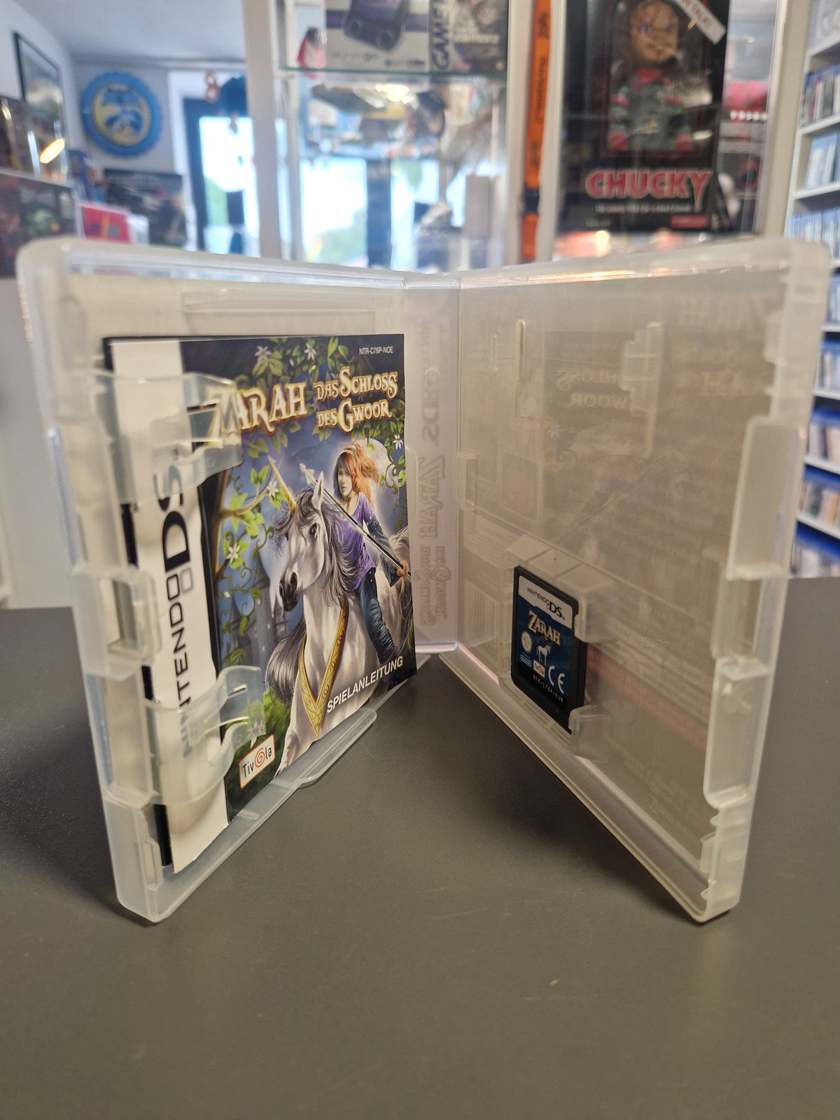 Geöffnete Nintendo DS Hülle von Zarah mit Spielemodul und gedruckter Anleitung.