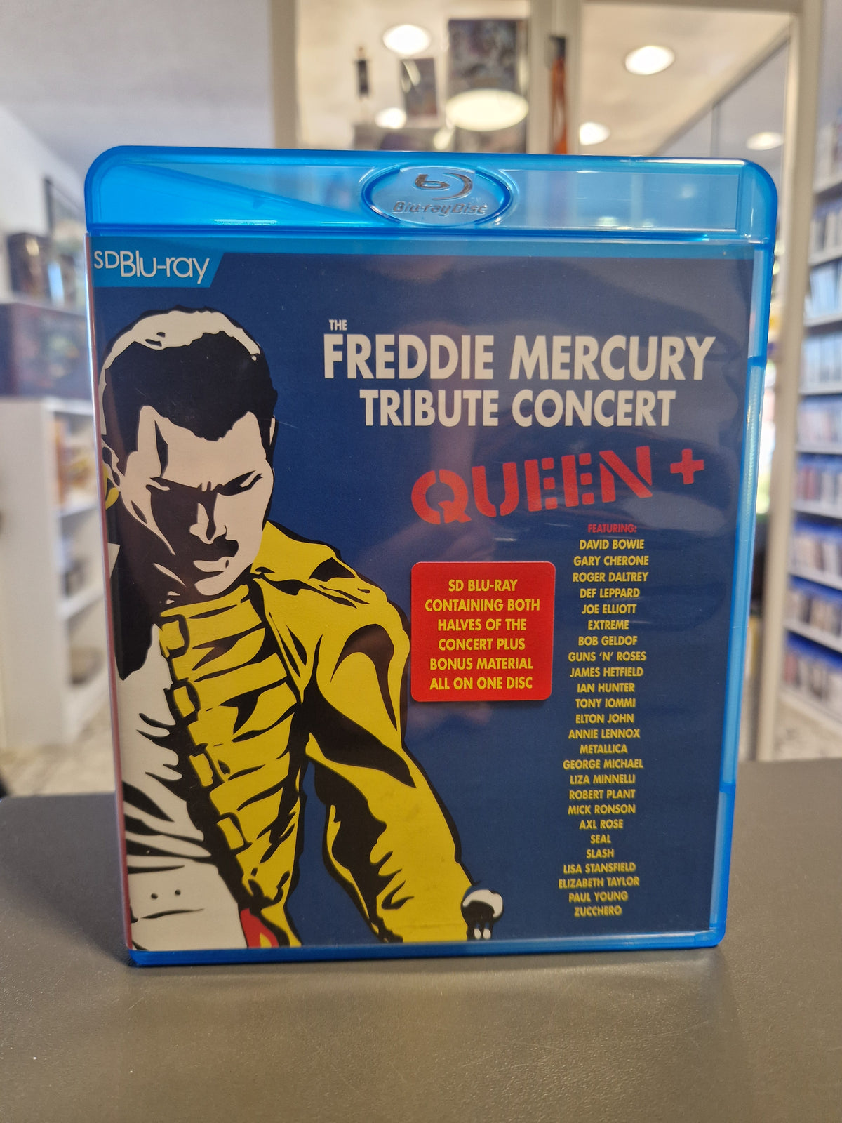 Vorderseite der Blu-ray Hülle von The Freddie Mercury Tribute Concert Queen mit gelber Freddie Mercury Silhouette.